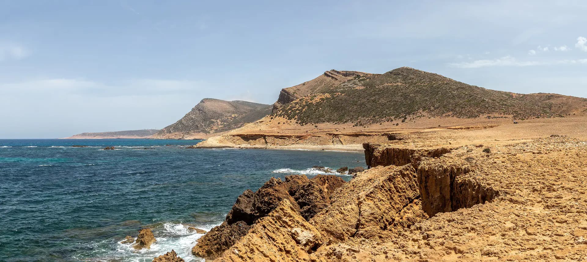 Golden cliffs and clear blue water on the El Haouaria coast, at the tip of the peninsula on the Cap Bon tour