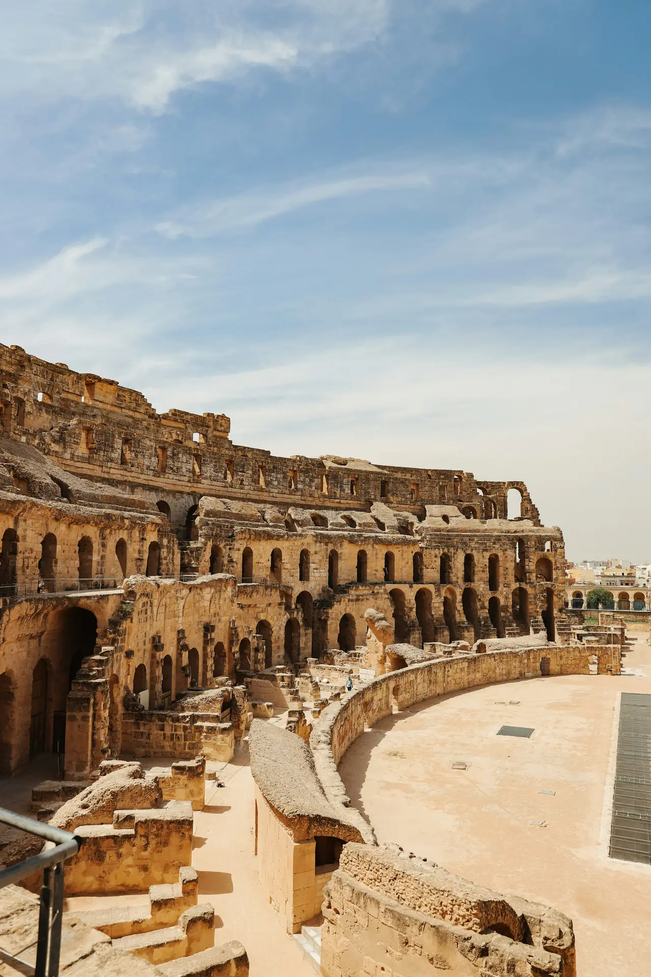 Upper tiers and arena of the El Jem amphitheatre under a blue sky on a Kairouan and El Jem tour